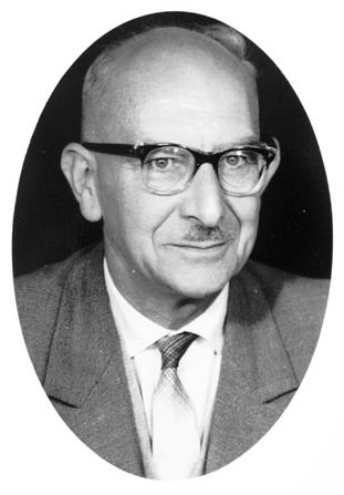 Schwarz-Weiß-Porträt eines älteren Mannes mit Brille und Schnurrbart in einem ovalen Bildausschnitt.