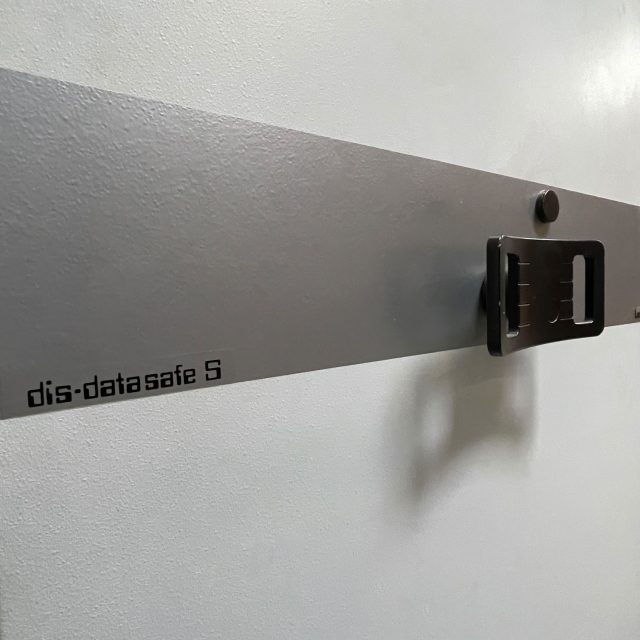 Graue Metallfront eines Datensafes mit schwarzem Griff und der Aufschrift dis-datasafe S.