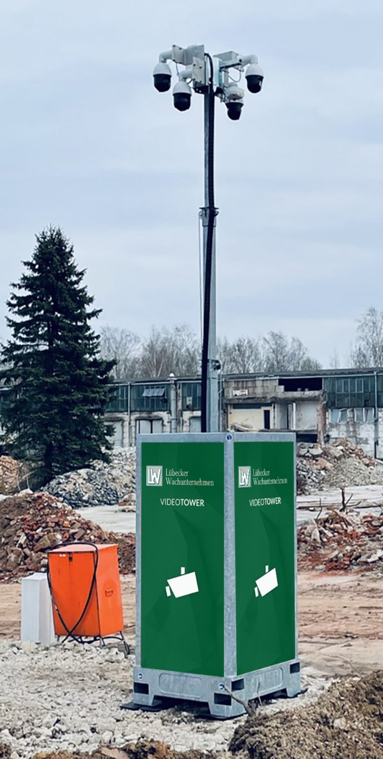 Mobiler VideoTower zur Baustellenüberwachung Ein mobiler Überwachungsturm mit mehreren Kameras an einem hohen Mast steht auf einem Gelände mit Schutt und Trümmern.